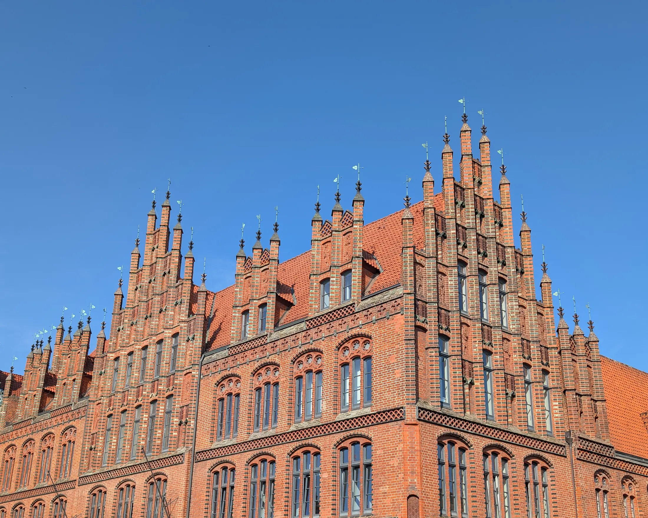 Die roten Staffelgiebel des Alten Rathauses in Hannover vor blauem Himmel